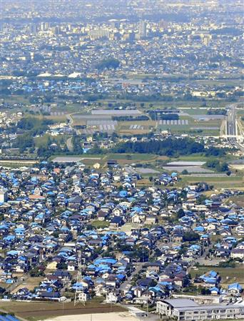 シートに覆われた家屋が目立つ熊本県益城町。奥は熊本市街＝１４日（共同通信社ヘリから）