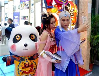深セン国際文化産業博覧交易会（深セン）文博会）の会場で写真を撮るアニメファン＝１２日、広東省深セン）市（中国新聞社）