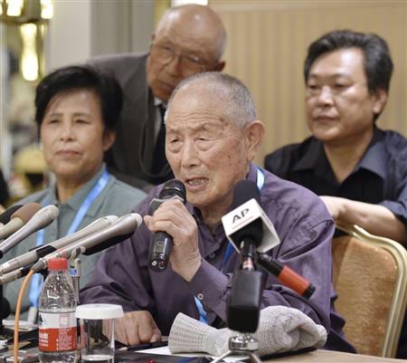 三菱マテリアルとの和解を正式発表し、記者会見する元労働者の閻玉成さん（手前）ら＝１日、北京（共同）