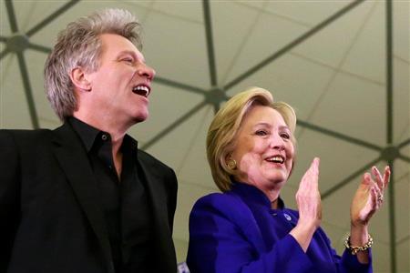ロック歌手のジョン・ボンジョビ氏（左）と並ぶヒラリー・クリントン前国務長官＝１日、米ニューアークのラトガース大学ニューアーク校（ロイター）