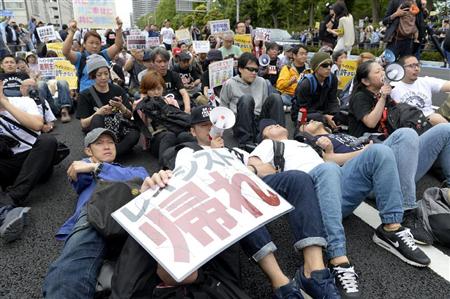 ヘイトスピーチ団体のデモ中止を求め、路上に座り込む人たち＝５日午前、川崎市