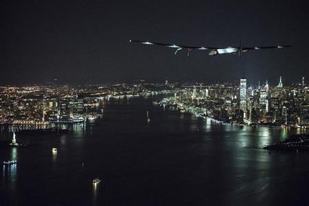 ジョン・Ｆ・ケネディ空港に着陸する態勢を取る「ソーラーインパルス２」。左下に見えるのは「自由の女神」像＝１１日、ニューヨーク（ＡＰ）