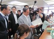 ふるさと納税の寄付額が平成２７年度に全国１位になった宮崎県都城市役所を訪れ、ふるさと納税の事務手続きを行う職員を激励する菅義偉官房長官＝１５日午前、宮崎県都城市役所（小川真由美撮影）