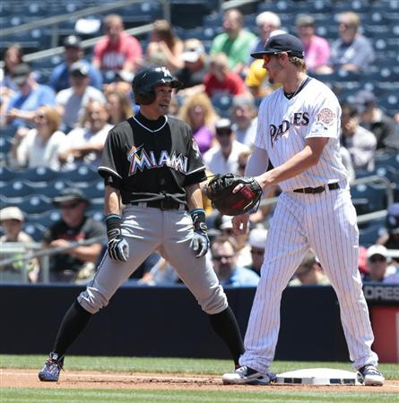 日米通算４２５６安打となる内野安打を放ち、一塁で笑顔を見せるマーリンズのイチロー外野手（左）＝１５日、サンディエゴ（共同）