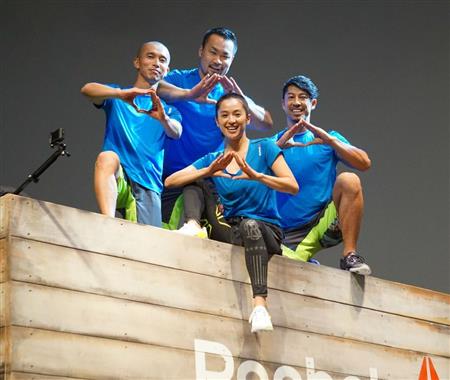 よじ登った壁の上でポーズを取る中村アンさん（中央）ら＝東京都港区（柳原一哉撮影）