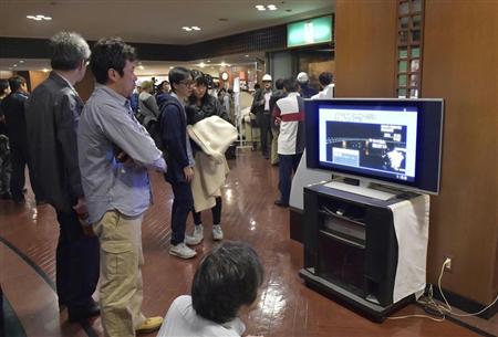 強い地震でホテルのロビーに集まり、テレビを見つめる宿泊客＝４月１６日未明、熊本市内のホテル