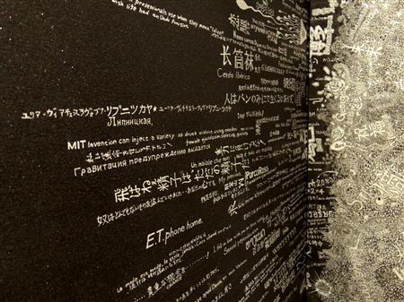黒地に銀のマーカーで文字を書き込んでいくＪｏｓｈｕａさんの作品