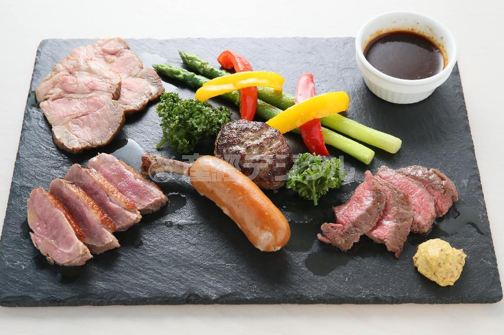 人気メニューの一つ「極上お肉のめぐみ」。牛肉、鴨肉、豚肉、アンガスバーグ、骨付きソーセージの盛り合わせ、和風ソースと粒マスタードで＝２０１５年１２月８日、京都市下京区（志儀駒貴撮影）