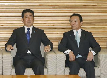 安倍首相に話しかける麻生財務相（右）＝２１日午前、首相官邸