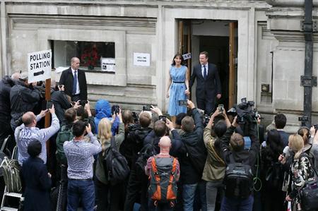 国民投票を行って投票所を出るキャメロン英首相夫妻＝２３日、ロンドン（ＡＰ）