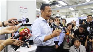 株主総会取材に訪れた報道陣に、ロボット携帯電話のロボホンなどシャープの新製品をアピールした台湾・鴻海精密工業の郭台銘会長=22日、台湾新北市 株主総会取材に訪れた報道陣に、ロボット携帯電話のロボホンなどシャープの新製品をアピールした台湾・鴻海精密工業の郭台銘会長=22日、台湾新北市