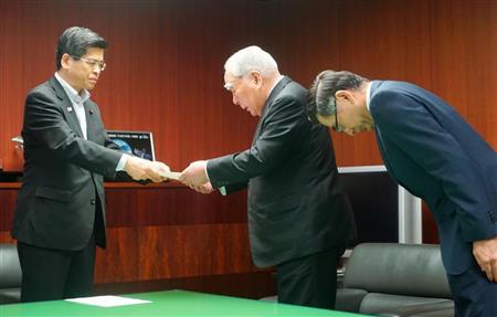 自動車の燃費不正問題で、石井国交相（左）から再発防止指示の文書を受け取るスズキの鈴木修会長。右は鈴木俊宏社長＝２４日、国交省