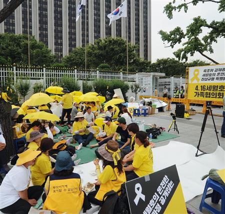旅客船セウォル号の沈没事故で政府の調査打ち切り方針に抗議しソウルの政府庁舎前で座り込みを続ける事故犠牲者遺族ら＝２７日（共同）
