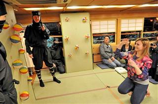 屋形船東京都協同組合が開催する「忍者屋形船」で手裏剣の体験を楽しむ外国人客