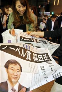 梶田隆章・東京大宇宙線研究所所長がノーベル物理学賞を受賞したことを伝える号外を受け取る人たち＝平成２７年１０月６日夜、ＪＲ大阪駅前（門井聡撮影）