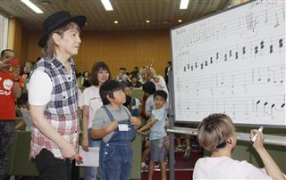 熊本県内の小中学生らと、地震からの復興ソングを作る小室哲哉さん（左）＝３日午後、熊本県御船町