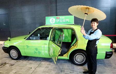 番傘で出迎える「伊右衛門」のラッピングをしたおもてなしタクシーの運転手＝５日、東京都千代田区