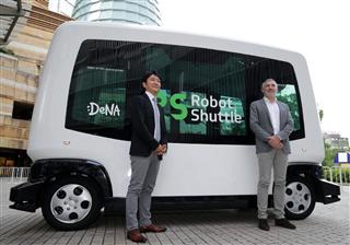 ＤｅＮＡが発表した無人運転バスの前でフォトセッションに応じる同社の中島宏執行役員（左）とイージーマイル社のジルベール・ガニェールＣＥＯ＝７日午後、東京都港区（松本健吾撮影）