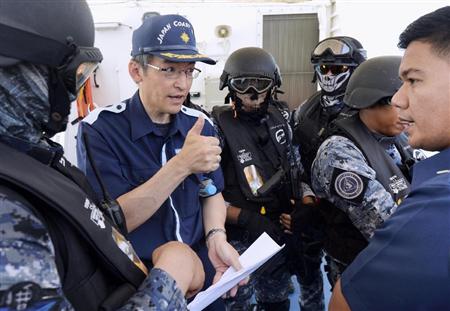 マニラ沖で行われた海賊対策の合同訓練で、フィリピン沿岸警備隊と打ち合わせをする海上保安官（左から２人目）＝１３日（共同）