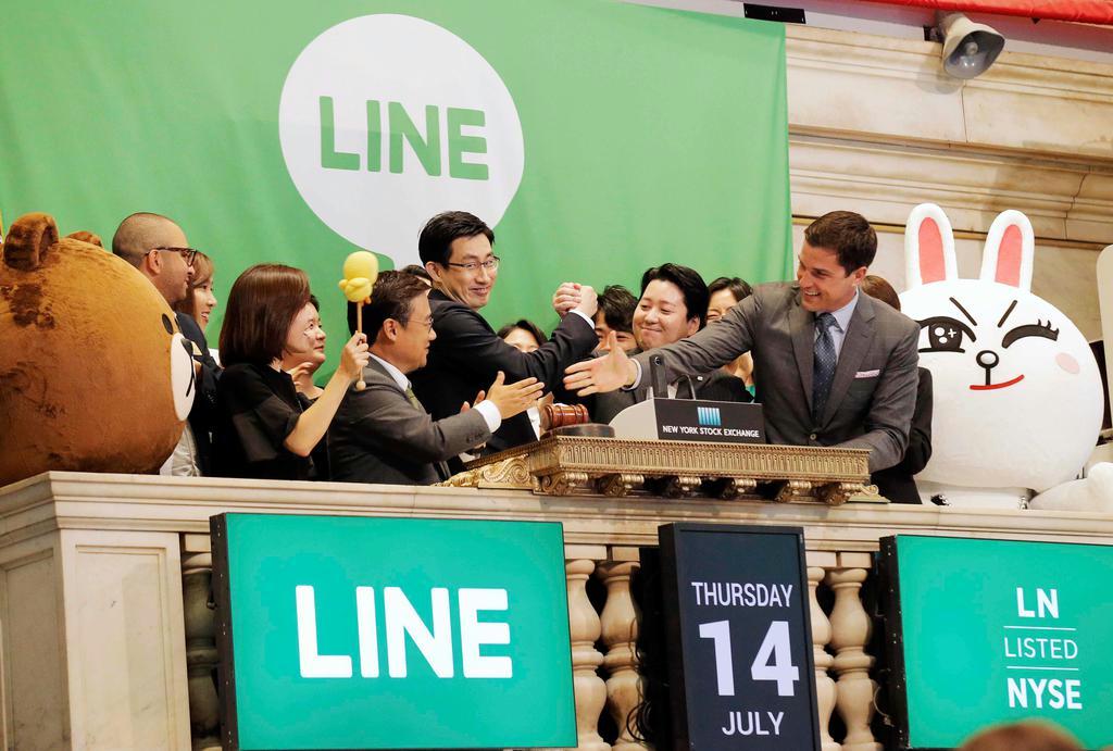 米ニューヨーク証券取引所に株式を上場し喜ぶＬＩＮＥの幹部ら＝１４日（ロイター）