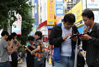 スマートフォン向けアプリ「ポケモンＧＯ」をプレイする利用者＝２２日午後、東京・秋葉原（古厩正樹撮影）