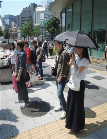 日傘で強い日差しを避ける女性