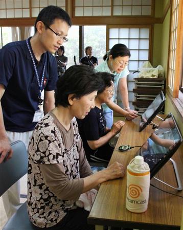 町から無料配布された歩数計を端末につなぎ、保健師とともに歩数や健康状態を確認する千葉県白子町の町民＝１２日