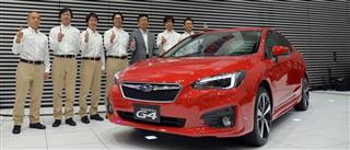 富士重工業の「新型インプレッサ」と開発メンバー＝２６日