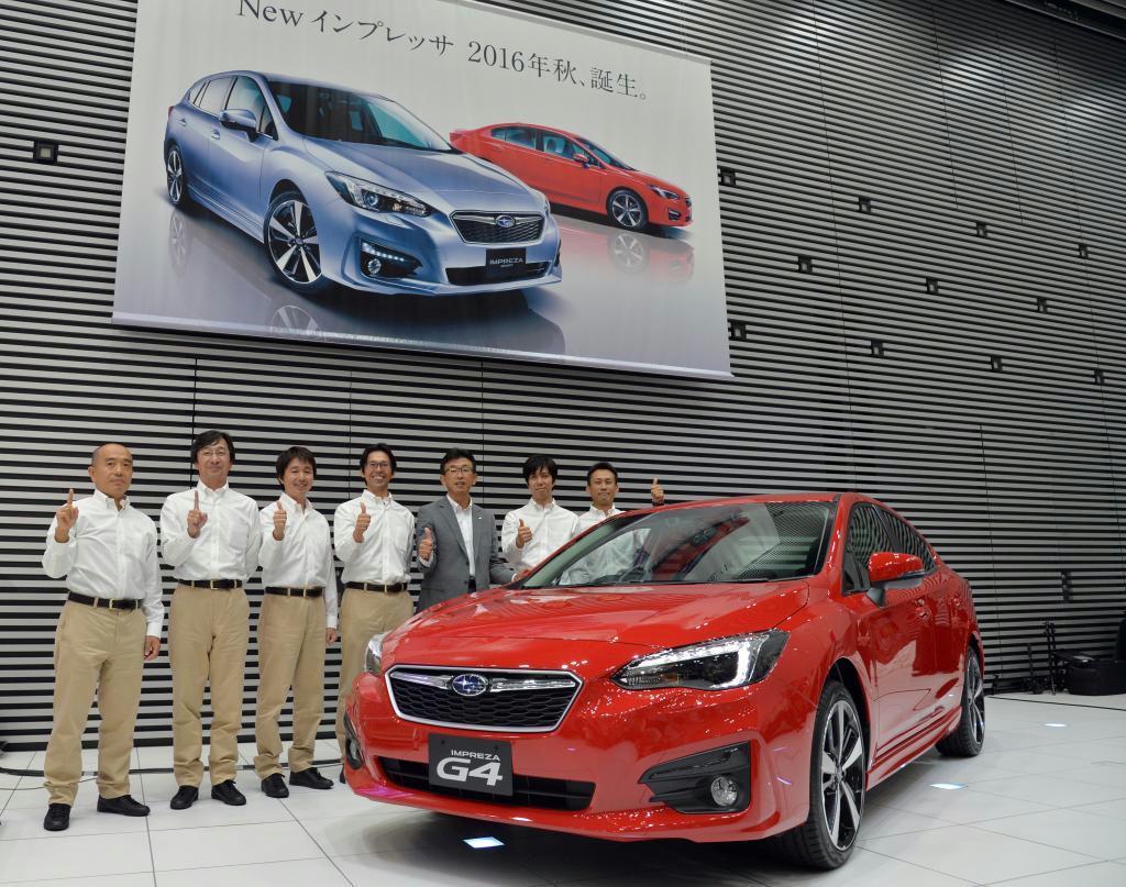 富士重工業の「新型インプレッサ」と開発メンバー＝２６日