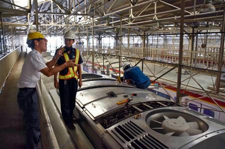インドネシアの首都ジャカルタにある車両基地で、冷房の点検作業を見守る前田健吾さん（左）＝６月２日（共同）