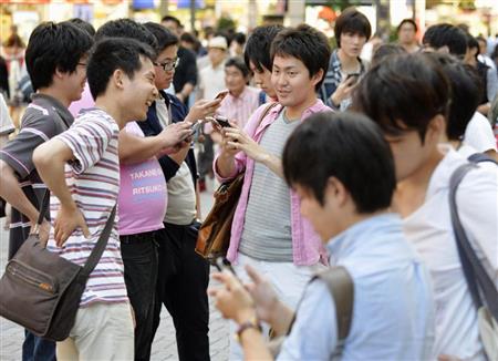 路上でスマートフォン向けゲーム「ポケモンＧＯ」を楽しむ若者＝２３日午後、東京・秋葉原