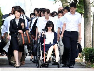 提訴のため車椅子で大阪地裁に入る原告=27日午後、大阪市北区の大阪地裁 提訴のため車椅子で大阪地裁に入る原告=27日午後、大阪市北区の大阪地裁