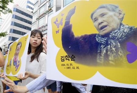 「和解・癒やし財団」の設立会合が開かれた建物前で抗議活動をする市民団体メンバー＝２８日、ソウル（共同）