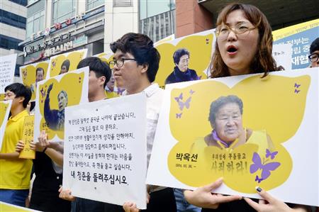 「和解・癒やし財団」の設立会合が開かれた建物の前で抗議行動する市民団体メンバー＝２８日、ソウル（共同）