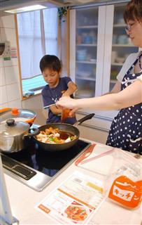 酢豚の調理を手伝う男子児童＝さいたま市
