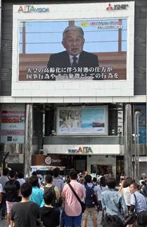 天皇陛下のビデオメッセージに足を止めて見入る通行人＝８日午後、東京都新宿区＝撮影・春名中）