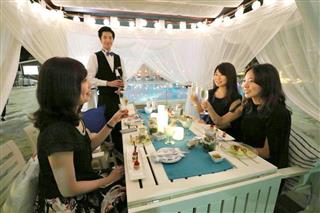 プールサイドの「カバナ席」で、スパークリングワインで乾杯をする女性たち＝７月、東京都港区のグランドプリンスホテル新高輪