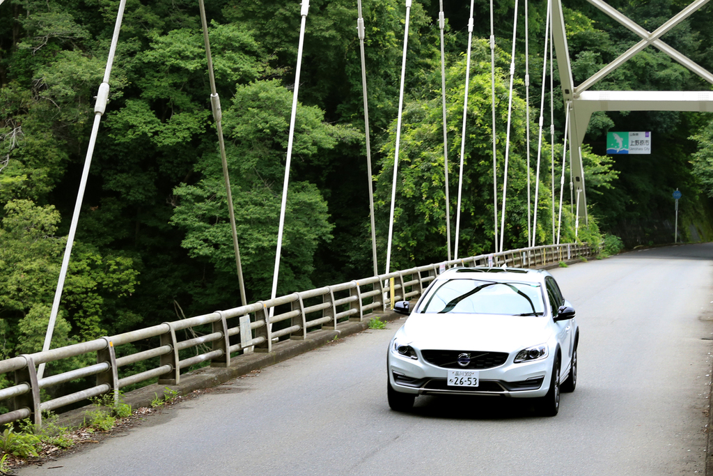 桂川に架かる橋の上を走るボルボ「Ｖ６０ クロスカントリー」。橋の奥は山梨県。手前は神奈川県。