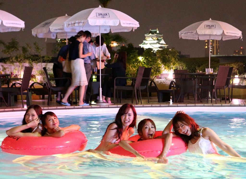 ホテルニューオータニ大阪でナイトプールがオープン、大阪城が望めるプールで遊ぶ水着ギャル＝７月１４日夜、大阪市中央区（宮沢宗士郎撮影）
