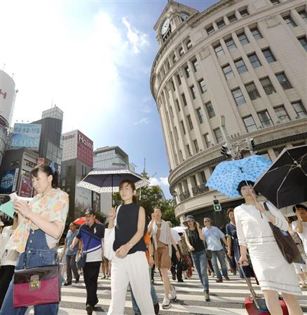 強い日差しに日傘を差して歩く人たち＝１７日午後、東京・銀座