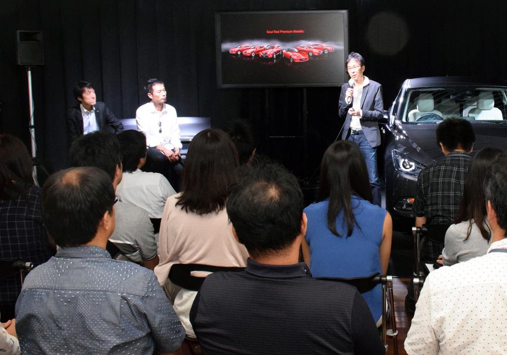 マツダのカラーデザインについて語る岡本圭一氏。向かって左にはデザイン本部主幹の田中秀昭氏（左端）と、新型アクセラのチーフデザイナーを務めた玉谷聡氏
