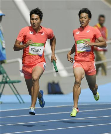 男子４００メートルリレー予選第１走者の山県（右）からバトンを受け取る第２走者の飯塚＝リオデジャネイロ（共同）