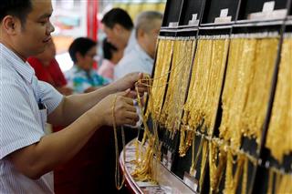 金のネックレスが並ぶバンコクの宝飾店。世界経済の不確実性が高まり、金に投資マネーが流入している（ロイター）