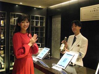 カラフル・ボードが開発した人工知能アプリを使った利き酒サービス。福島の地酒を店員に勧められたモデルの梨衣名さん＝２４日、東京都新宿区の伊勢丹新宿本店（松村信仁撮影）