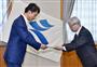 九州電力の瓜生道明社長（右）に川内原発の一時停止を求める要請書を手渡す鹿児島県の三反園訓知事＝２６日午後、鹿児島県庁