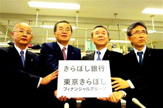 子銀行合併後の行名や戦略を発表した東京ＴＹＦＧの味岡桂三社長（左から２人目）ら＝２６日、東京都中央区