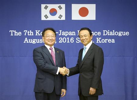 日韓財務対話で握手を交わす韓国の柳一鎬・経済副首相兼企画財政相（左）と麻生財務相＝２７日、ソウル（共同）