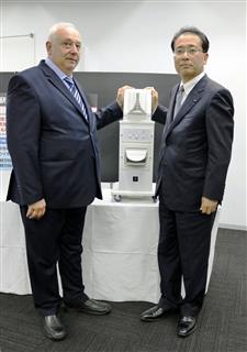 プラズマクラスターの結核予防効果の臨床試験で使われたイオン発生装置を披露するシャープの沖津雅浩常務(右)とジョージア国立結核病院のザザ・アヴァリアニ院長=8日、東京都港区(宇野貴文撮影) プラズマクラスターの結核予防効果の臨床試験で使われたイオン発生装置を披露するシャープの沖津雅浩常務(右)とジョージア国立結核病院のザザ・アヴァリアニ院長=8日、東京都港区(宇野貴文撮影)