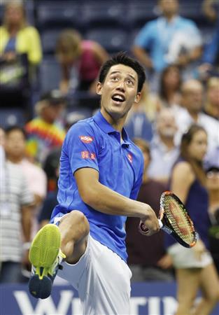 男子シングルスでベスト４進出を決め、笑顔で観客席にボールを打ち込む錦織圭＝ニューヨーク（共同）