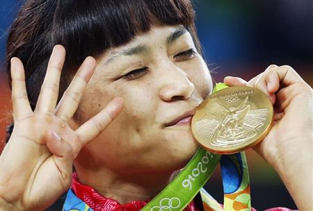 ８月、リオ五輪レスリングの女子５８キロ級で獲得した金メダルにキスをする４連覇達成の伊調馨選手＝リオデジャネイロ（共同）